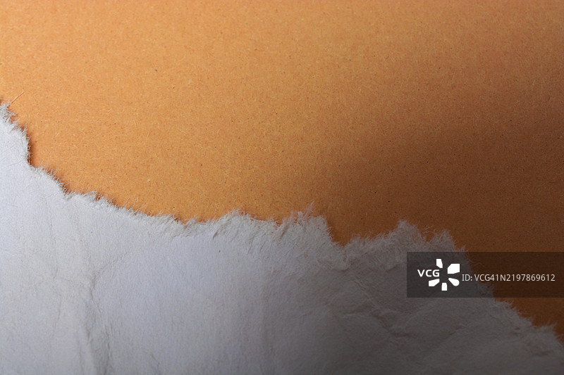 一片撕裂的纸张放置在简单的背景上图片素材