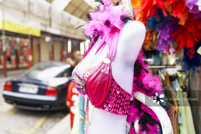 街道上商店外侧面展示的模特，穿着红色比基尼，周围没有人。图片素材