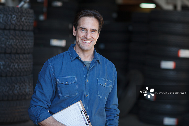 汽车修理工肖像，轮胎修理专家，小企业主在汽车车库中展望未来，充满自豪感。图片素材