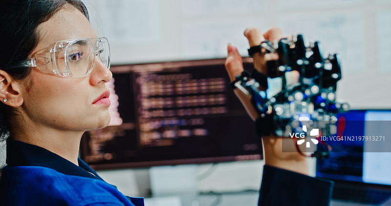 年轻女性工程师在科技实验室操作机器人手臂，进行人工智能和机器学习开发。人工智能与机器人技术开发。图片素材