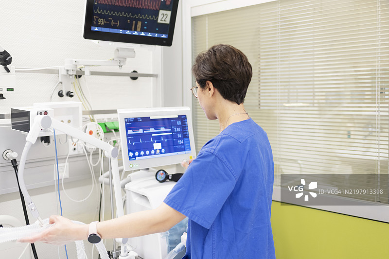 女医生在重症监护室操作医疗呼吸机图片素材