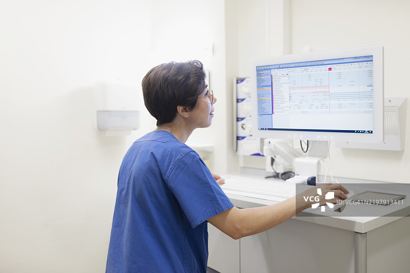 护士在重症监护室的电脑显示器上编辑数字病人档案图片素材