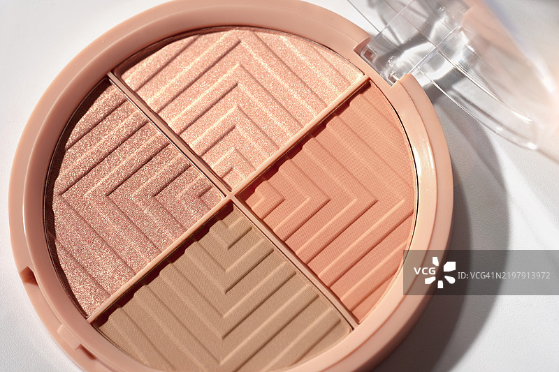 女性化妆品 - 面部粉饼腮红调色板，白色背景上的古铜粉。2025年年度流行色摩卡慕斯的时尚概念。图片素材