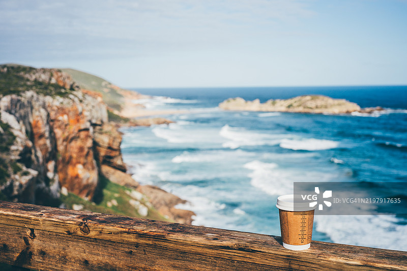 海边木凳上的咖啡杯。图片素材