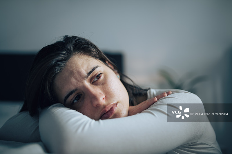 年轻女性独自在家中感到抑郁。图片素材