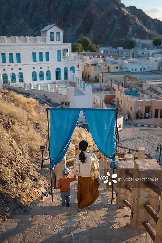 母亲和孩子在马斯喀特的穆特拉赫堡的风景台阶上漫步图片素材