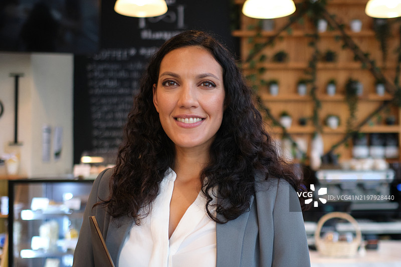 在咖啡店里，长发的快乐女性图片素材