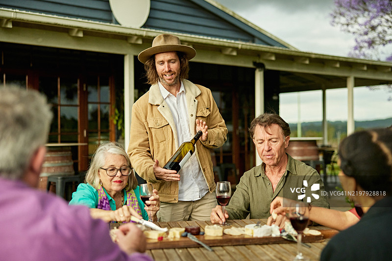 微笑的酒窖门口接待员向客人介绍红酒精选图片素材
