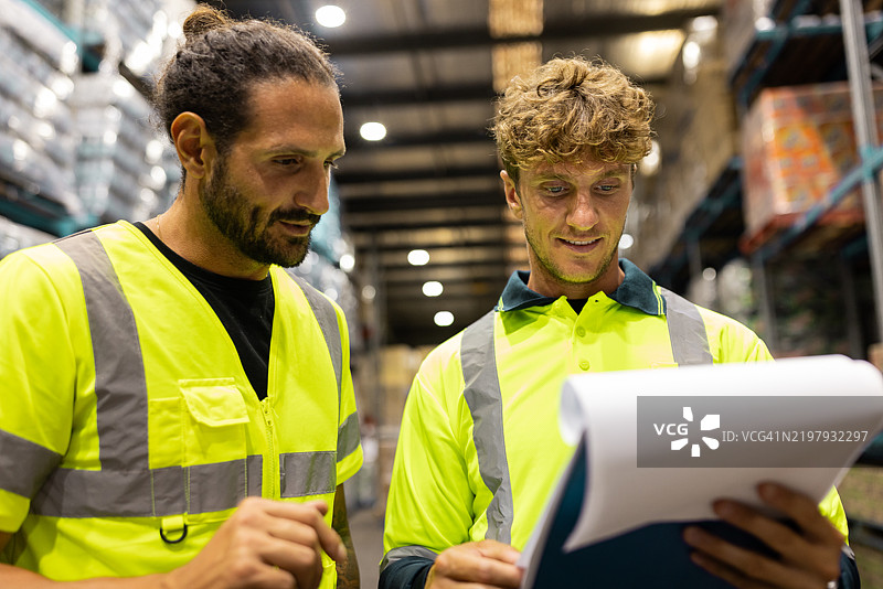 仓库工人在储存设施中检查文件图片素材