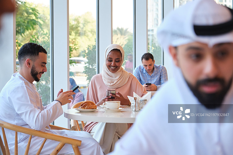 微笑的女人在咖啡馆与男人交谈图片素材