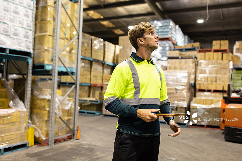仓库工人在有序的储存设施中用夹板检查库存图片素材