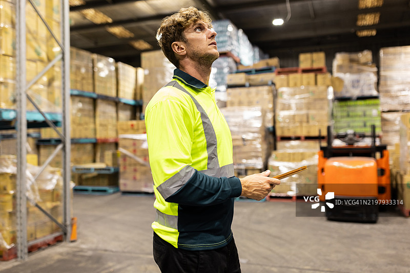 仓库工人在储存设施中用夹板检查库存图片素材
