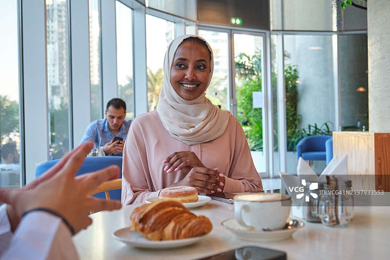 微笑的女性穿着阿巴亚与男友交谈图片素材