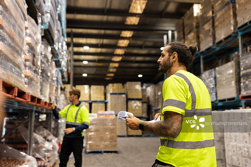 工业环境中仓库工人整理和检查库存图片素材