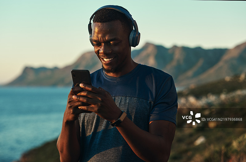 年轻强壮的运动员穿着运动服，戴着耳机听音乐图片素材