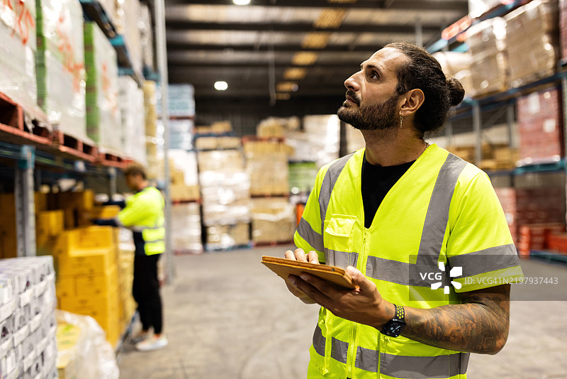 仓库员工整理库存并使用平板电脑进行库存管理图片素材