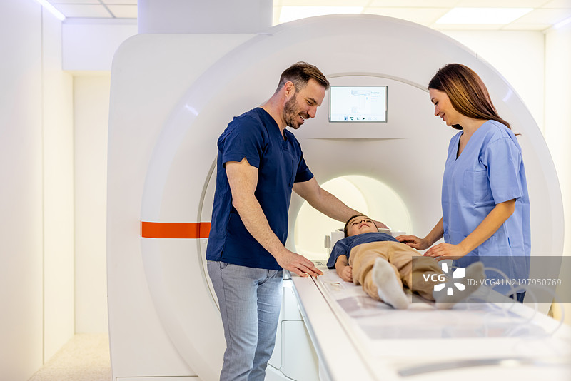 医疗人员在现代诊所协助儿童进行MRI扫描图片素材