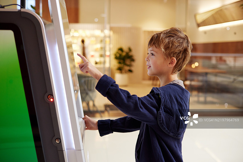 年轻男孩与触摸屏技术互动图片素材