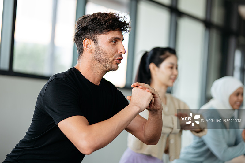 一群多元化的人在室内一起锻炼图片素材