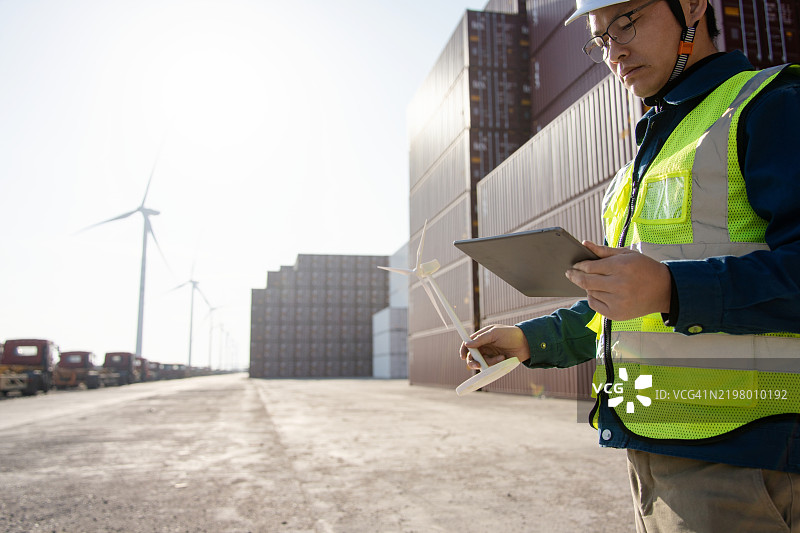 亚洲工程师在风电站使用数字平板电脑工作图片素材