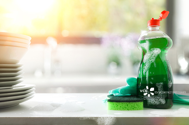 厨房里的洗碗液瓶、清洁垫和手套图片素材
