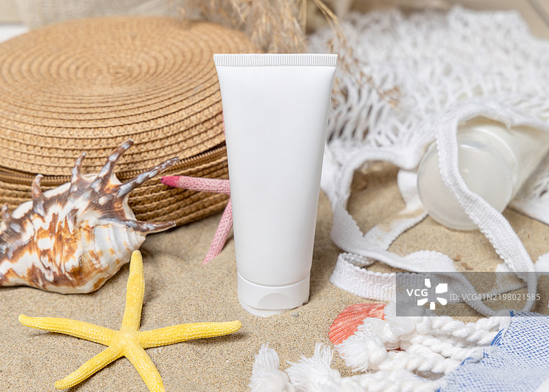 防晒霜管、太阳镜、毛巾、沙滩上的海星和贝壳、化妆品样机图片素材
