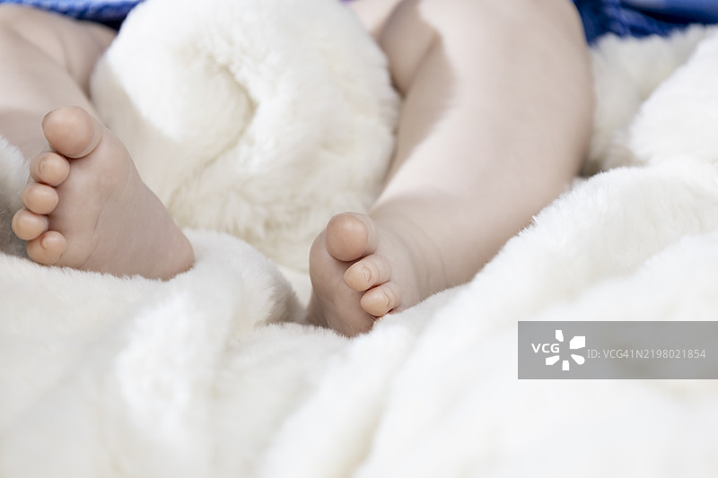 婴儿的腿躺在白色床上图片素材