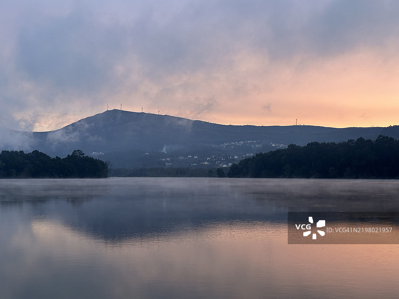 晨曦照耀着迷雾缭绕的米尼奥河及其周围的山脉，位于西班牙加利西亚的埃拉斯，奥罗萨尔。图片素材