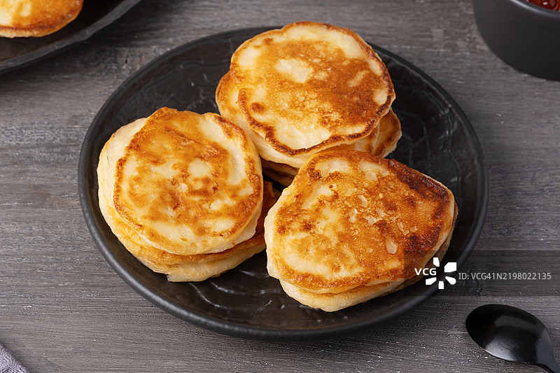 美味的金色煎饼堆叠在乡村风格的桌子上，配有鱼子酱图片素材