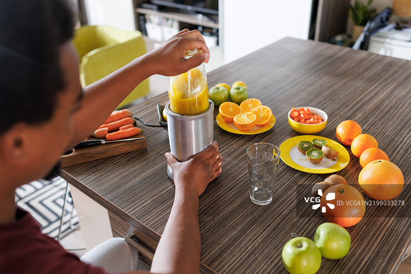 男子在厨房台面上用有机食材准备新鲜果汁图片素材