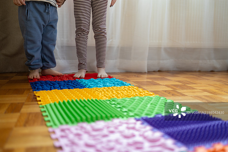 孩子的脚放在按摩垫上。图片素材