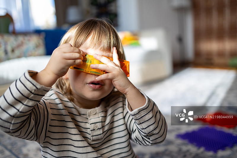 小孩在玩磁性积木，玩得很开心。图片素材