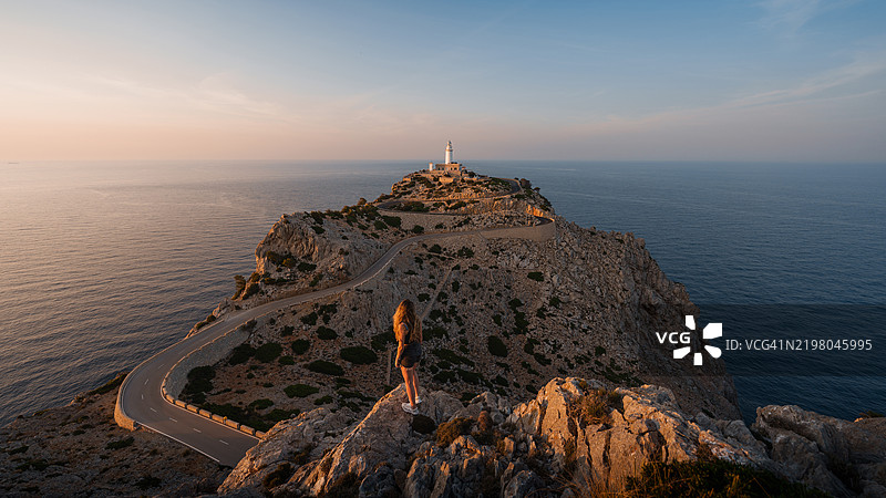 游客在西班牙马洛卡的福尔门托角灯塔欣赏日落图片素材