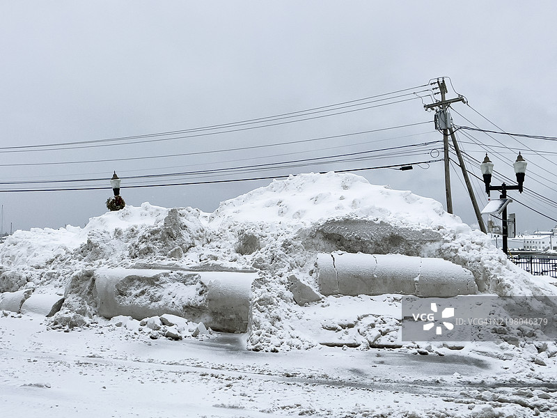 街灯和电线前面的大堆雪图片素材
