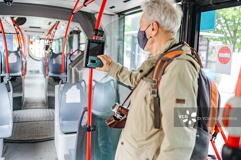 戴着口罩的老年游客乘坐城市公交车图片素材