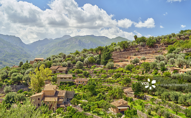 马略卡山区风景如画的梯田村庄，天空晴朗，轻云飘浮。图片素材