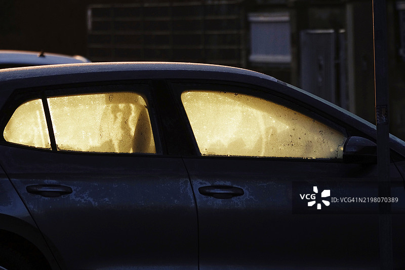 冬季德国的汽车挡风玻璃上覆盖着霜花，日出时分图片素材
