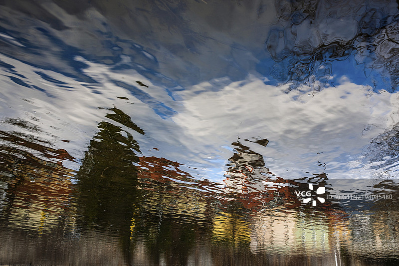 奥地利施蒂利亚州莱本的穆尔河中倒映的建筑物图片素材