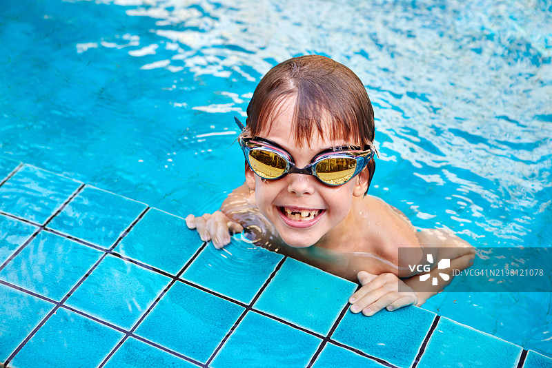 微笑的孩子在游泳池中畅游图片素材