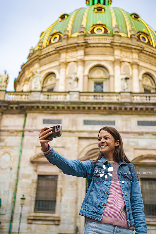 年轻女性在哥本哈根标志性地标前自拍图片素材