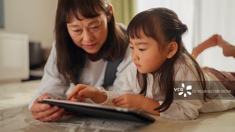 祖母和小孩一起在数字平板上学习图片素材