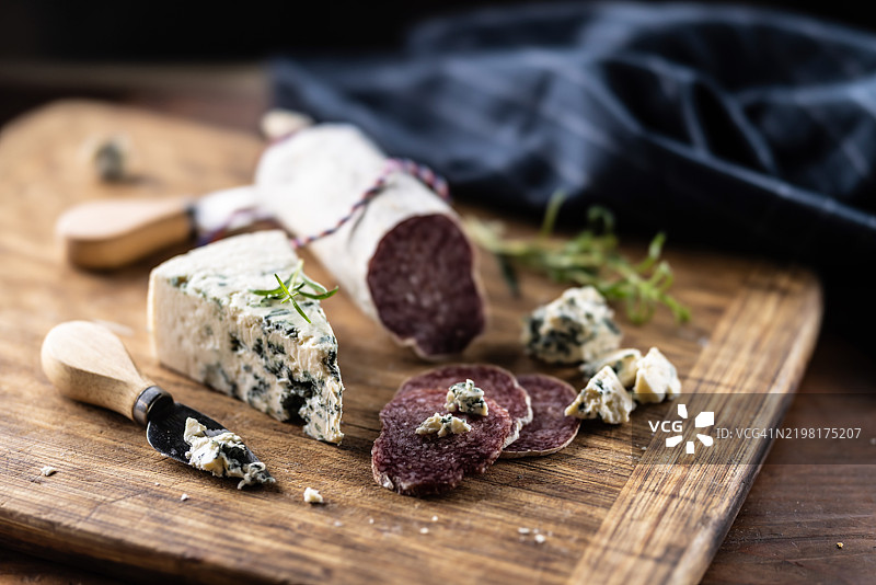 切菜板上的蓝纹奶酪与萨拉米香肠。图片素材