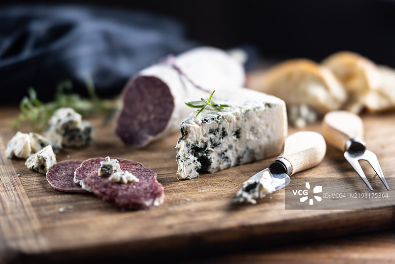 切菜板上的蓝纹奶酪与萨拉米香肠。图片素材
