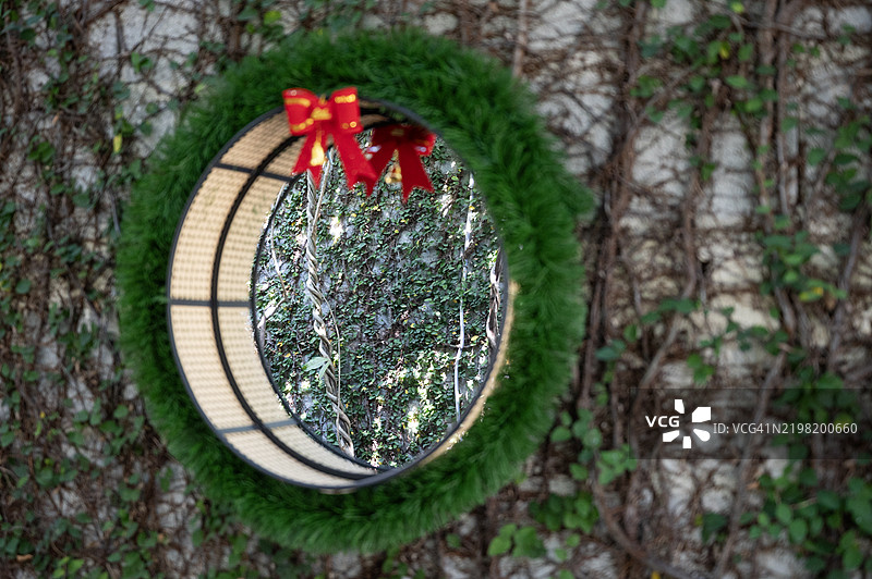 一圈带红色蝴蝶结的花环挂在墙上图片素材