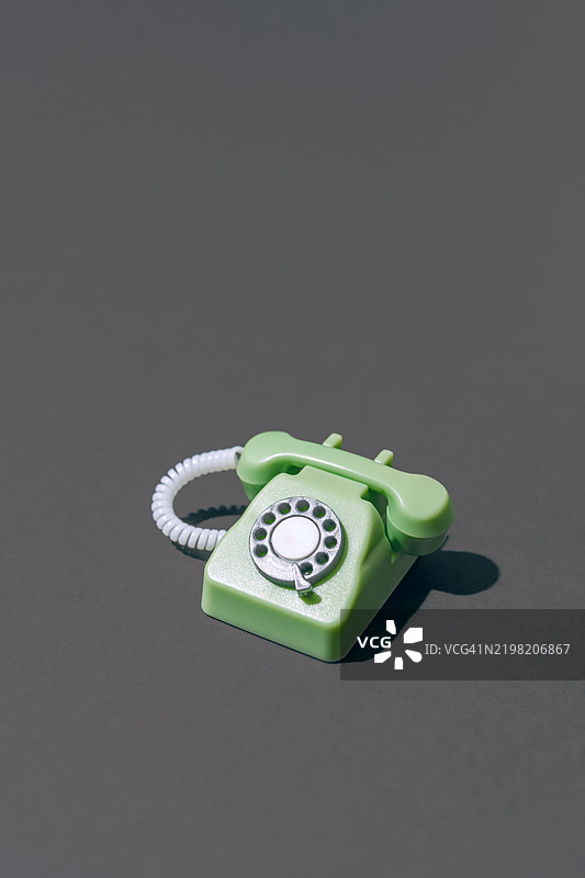 复古绿色旋转电话放在灰色表面上图片素材