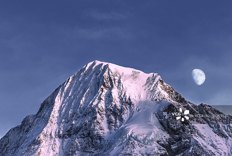 蒙克山与日落时的月亮。瑞士。图片素材