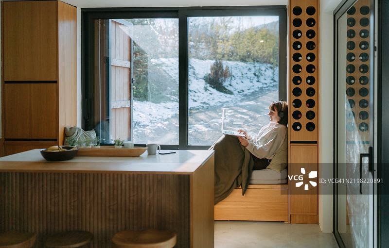 在小木屋里使用笔记本电脑的女人图片素材