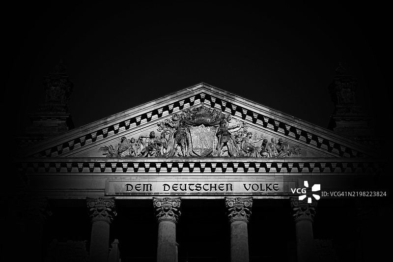 柏林国会大厦的黑暗中，铭文“Dem Deutschen Volke”显现。图片素材