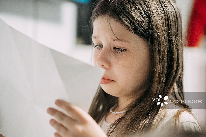 小女孩在家中阅读感人的信件图片素材