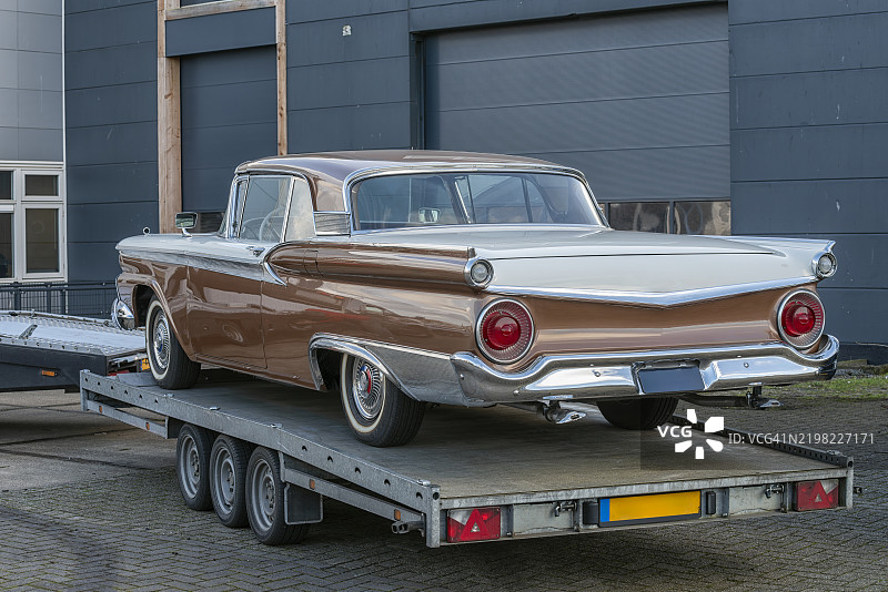 1959年的汽车停在车辆拖车外面图片素材